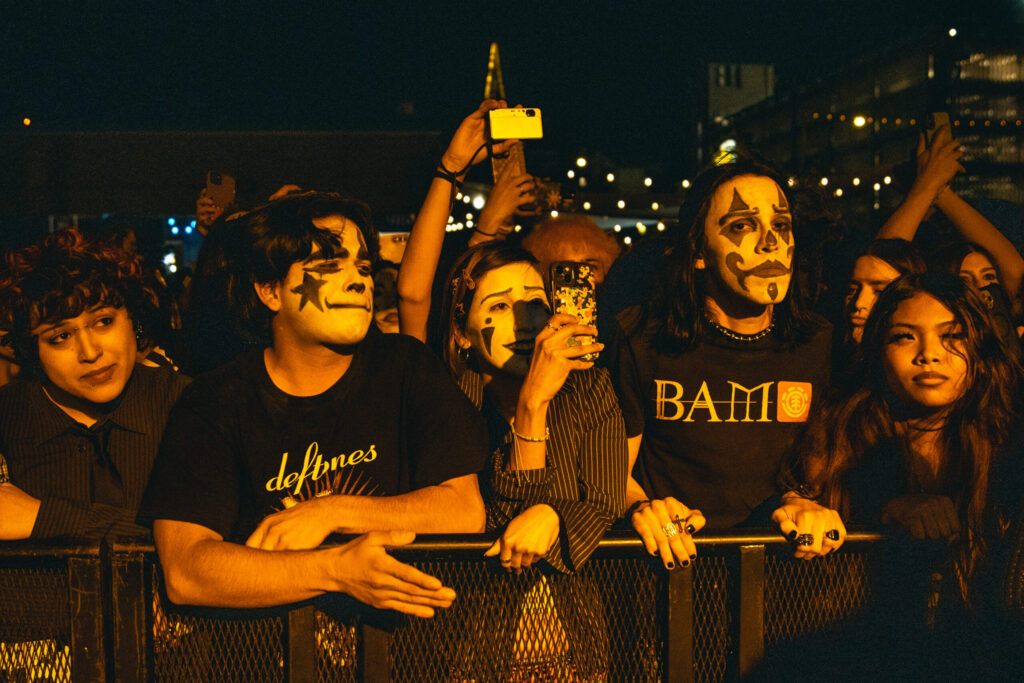 Fans line up at the barricade with jester makeup to listen to The Garden.